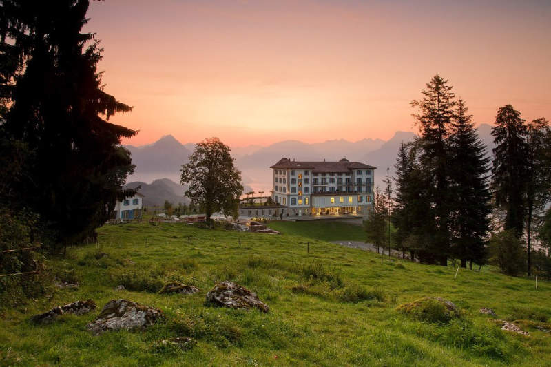 Heated infinity pool at Hotel Villa Honegg offers sweeping views of Swiss Alps