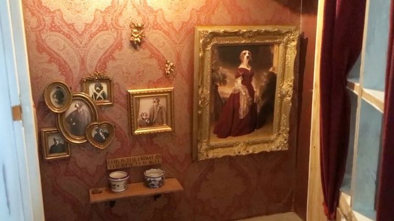 Dog house with portraits of Jessie hung on the walls