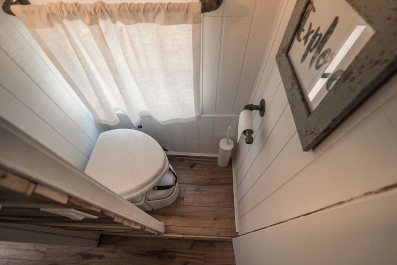 Tiny composing toilet sufficient to accommodate a person