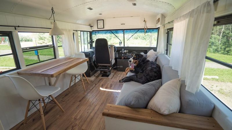 Living room with a folding table, sofa bed decked over the wood-patterned floor