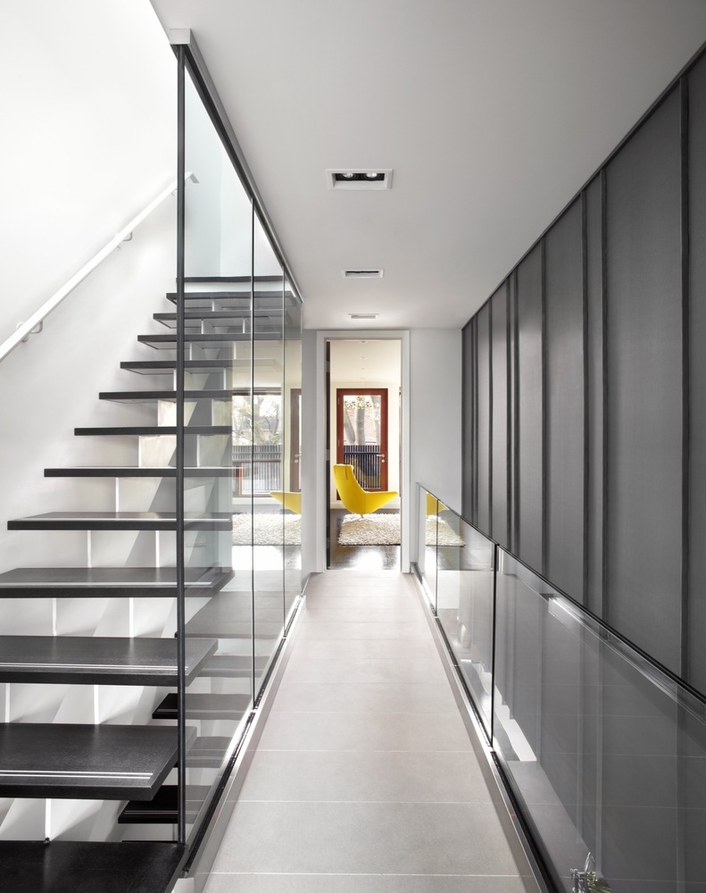 Elegant staircase by the side glass railing and wall