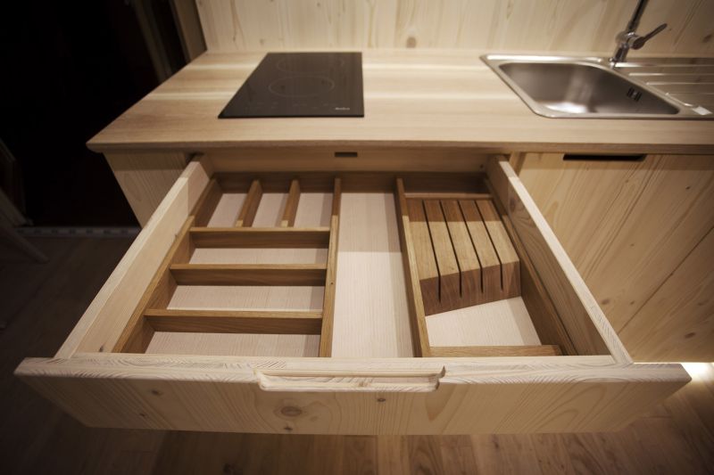Wooden cabinetry and all required utensils are included in the kitchen