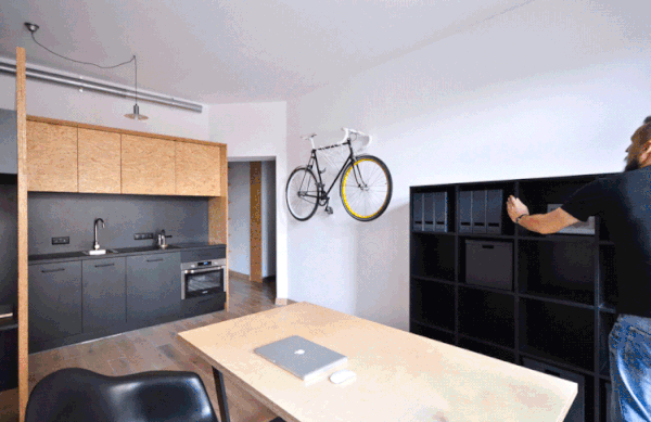 Slide-out shelving reveal the play room behind the work desk