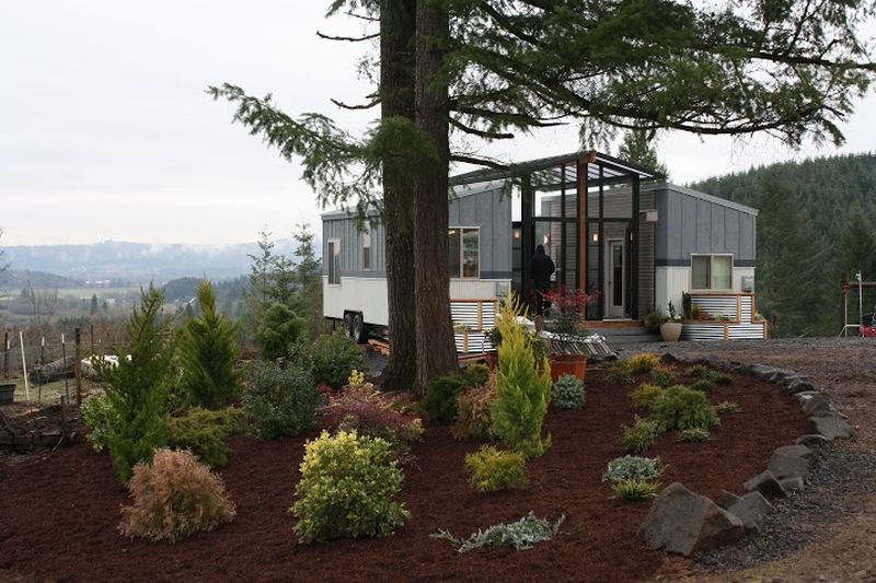 Ohana tiny house features a patio between two trailers