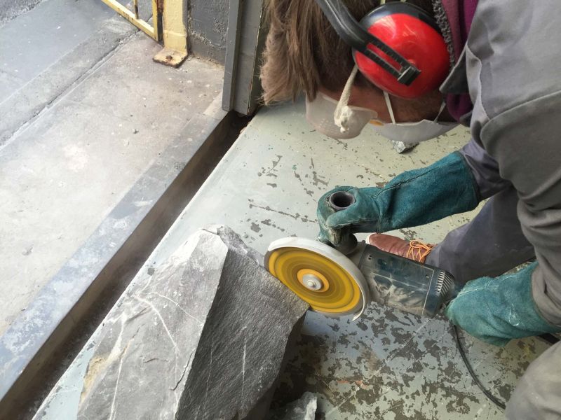 Lunar table by Jesse Ede features monotholic rock piercing through aluminum tabletop