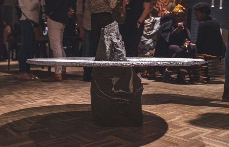 Lunar table by Jesse Ede features monotholic rock piercing through aluminum tabletop
