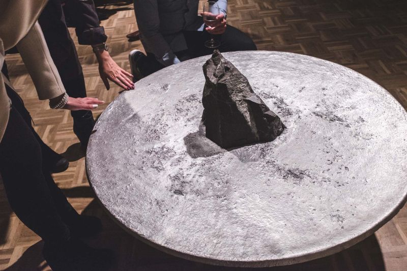 Lunar table by Jesse Ede features monotholic rock piercing through aluminum tabletop