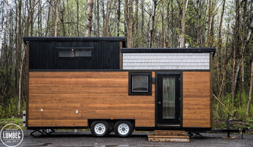 TH2 tiny house on wheels by Lumbec Covered with white pine, stained western red cedar and steel cladding, this 24-foot long tiny house on wheels promises a long life. It has a small living room area with a custom couch and table, a mid-size kitchen, bathroom with tub and a private bedroom loft. Furthermore, storage spaces are scattered throughout the home. 