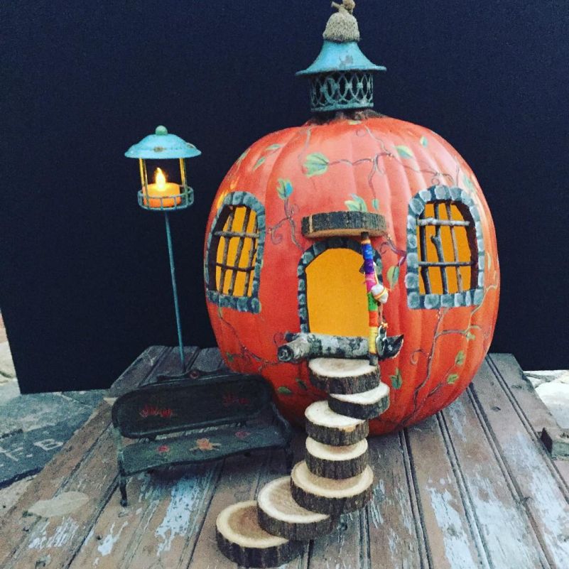 Pumpkin fairy house painted in beautiful patterns: two large windows and wooden slide staircase