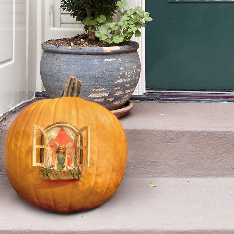 A little fairy peeking out of her pumpkin house