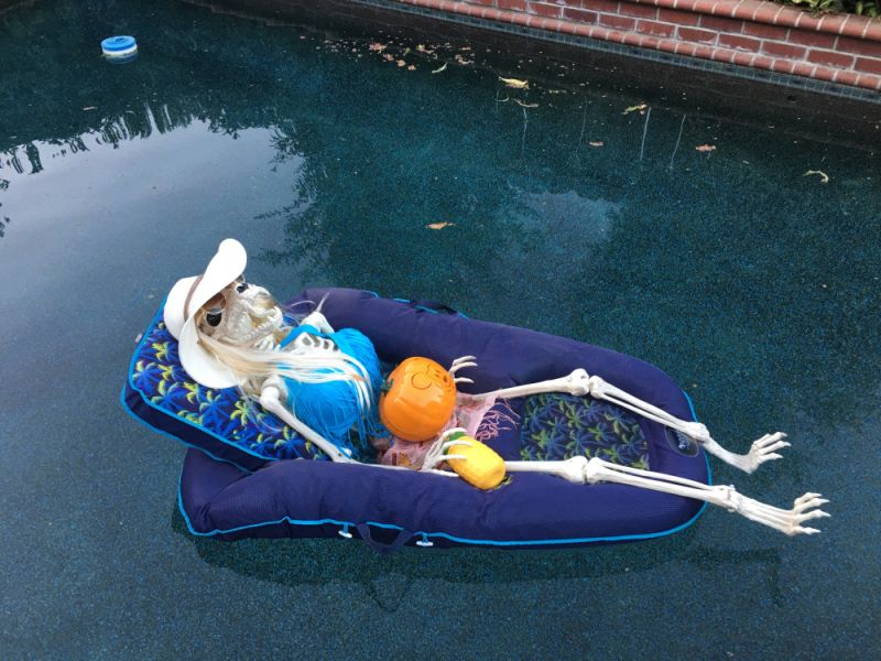 skeleton decoration in a pool over pool chair  