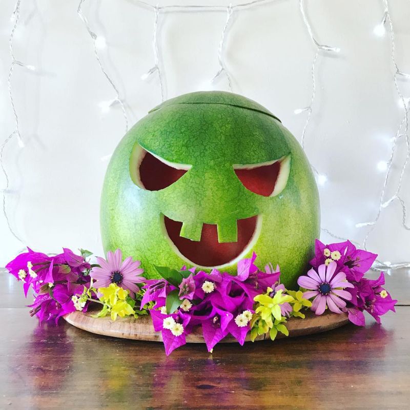 Watermelon jack-o'-lantern on a tray with flowers 