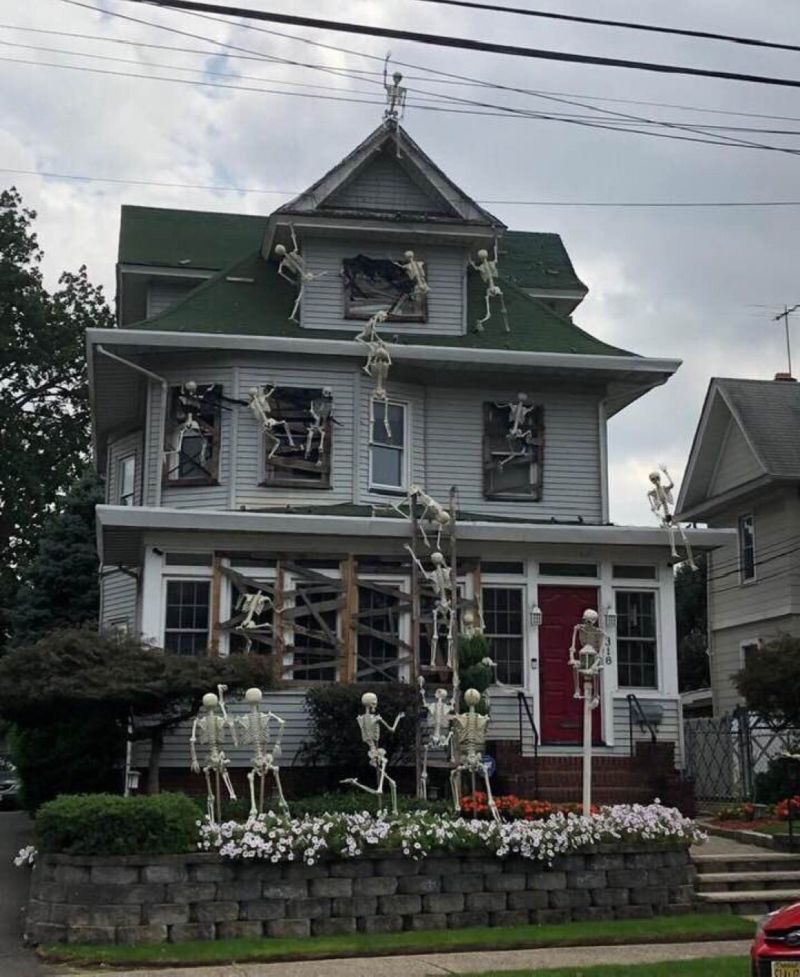 Skeletons climbing up a house 