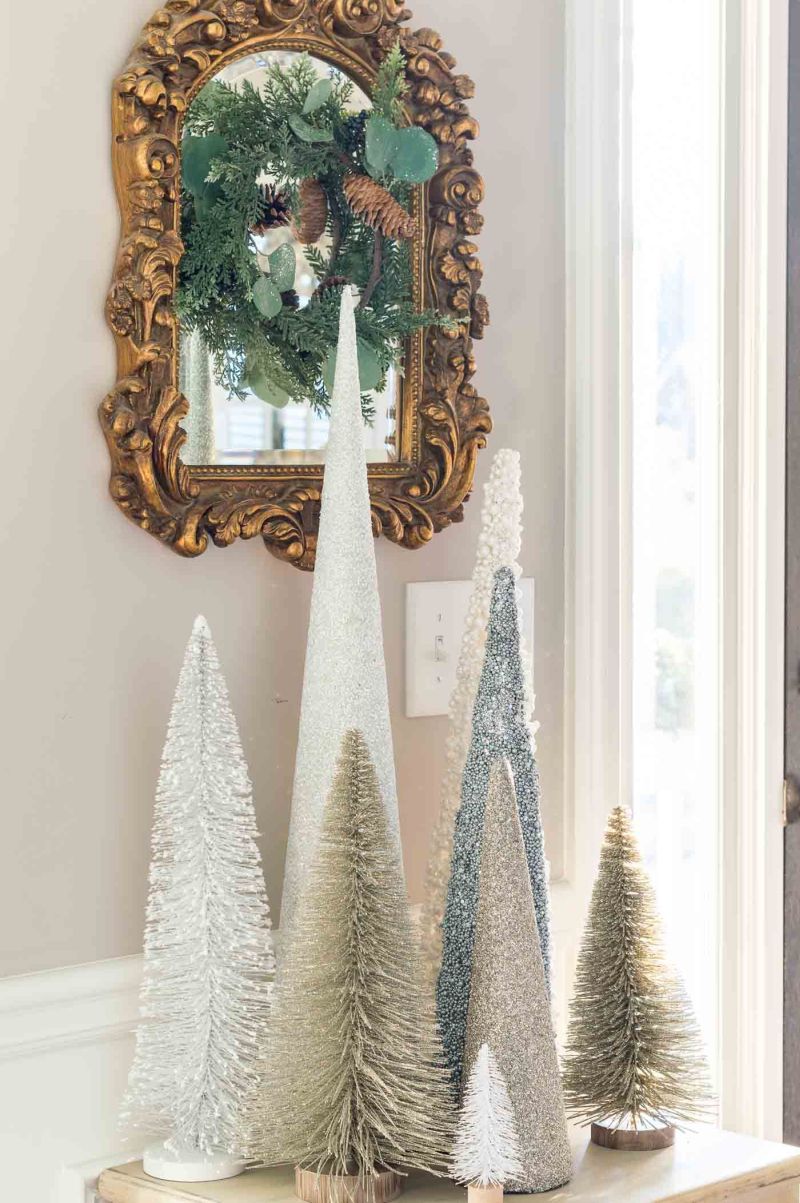 bottle brush Christmas trees placed on the entry table