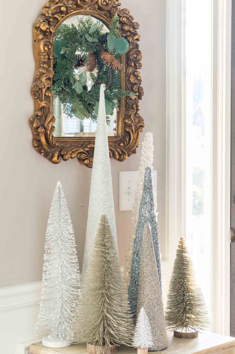 bottle brush Christmas trees placed on the entry table 