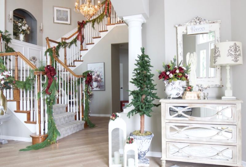 mini twinkle tree placed in a vintage urn along with a couple of lanterns 