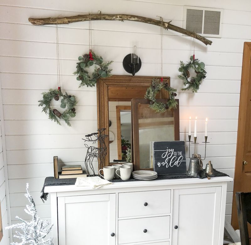 wreaths hanging on the wall with wood branch  