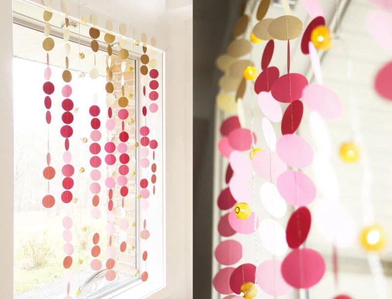 red and pink hanging paper garland on window  
