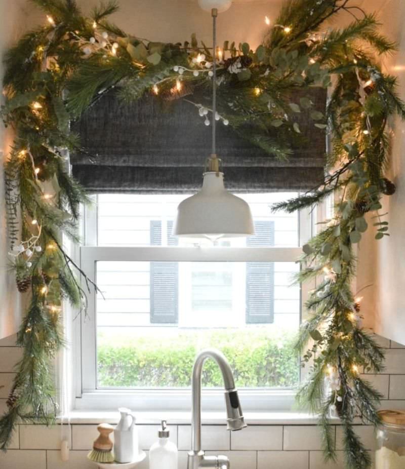 Christmas Window Decoration with green garland and lights  