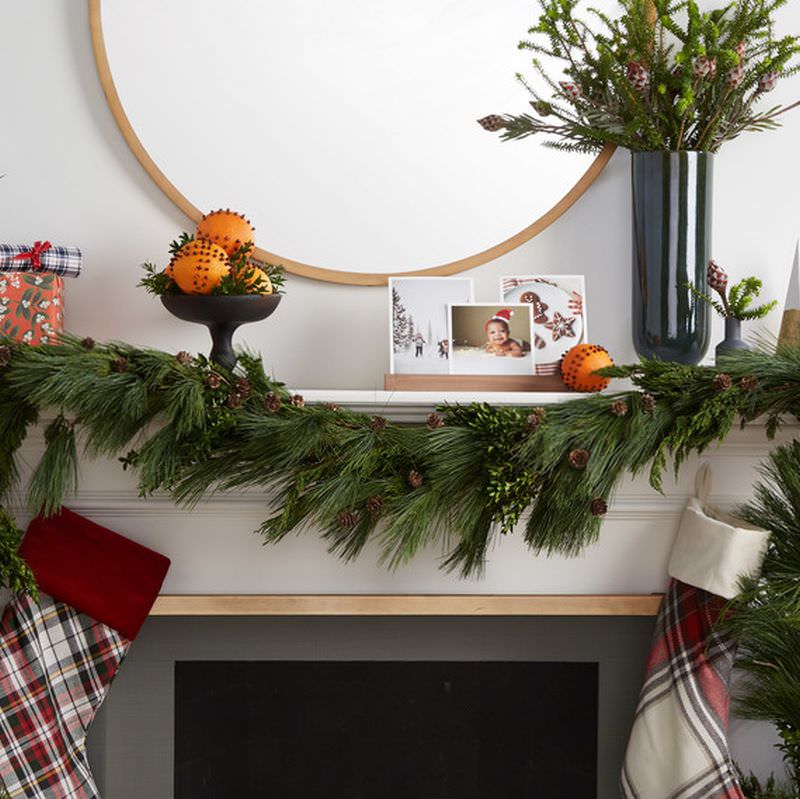 greens paired with traditional Christmas decorations on Fireplace Mantel 