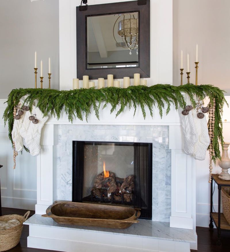 Christmas Fireplace Mantel Decoration with green garland and candles 