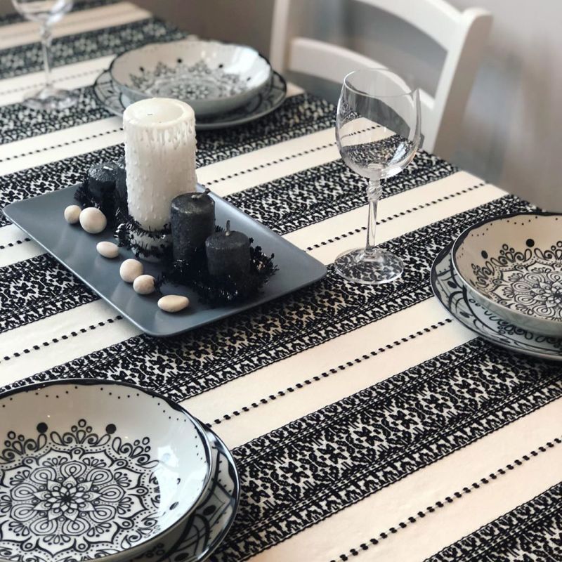 Christmas tablescape with black and white candles with river stones and glasses 