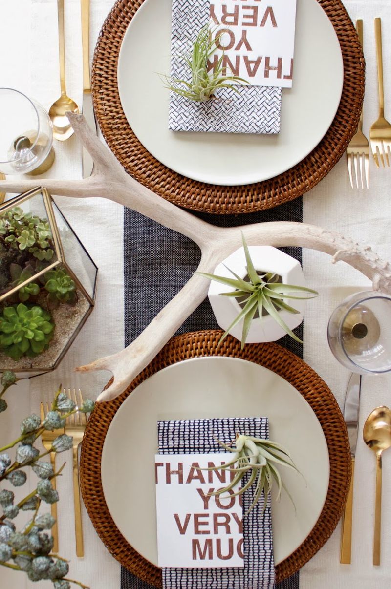 Modern organic Thanksgiving tablescape with geometric vases with air plants and glass terrariums with succulents