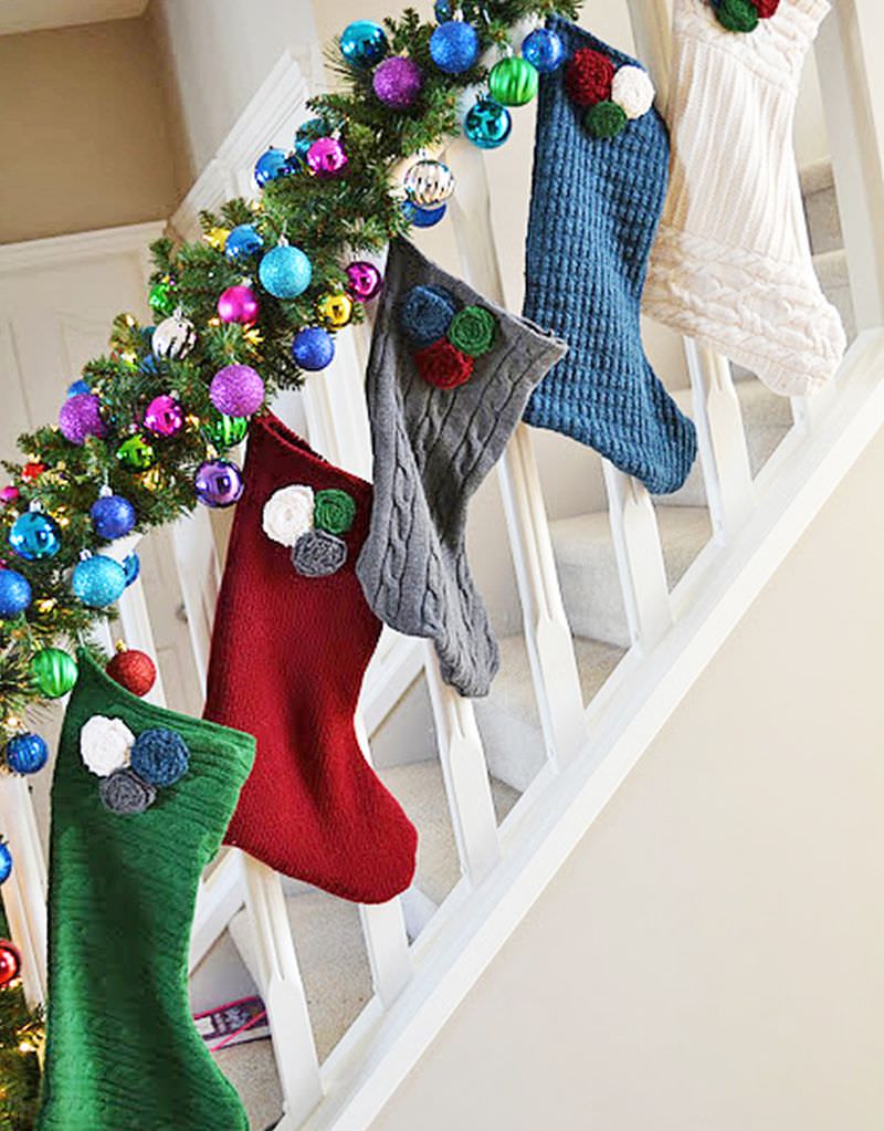 Stockings and Christmas tree ornament garland on staircase railing