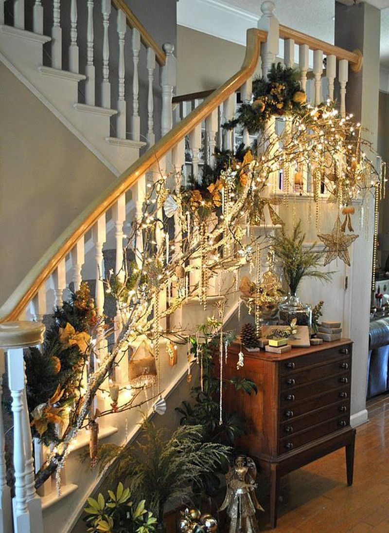 Dried tree branches and lights tied to staircase 