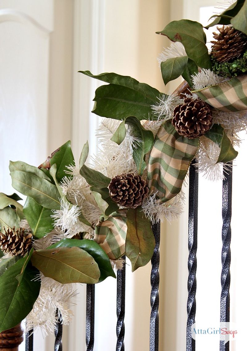 Christmas staircase decked with magnolia and gilded pine cone garland 