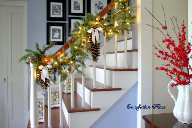Green garlands. lights and pine cones on staircase