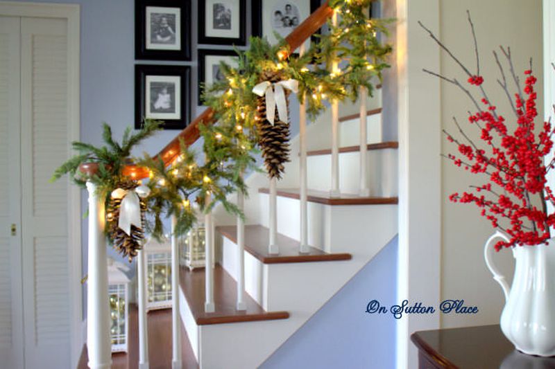 Green garlands. lights and pine cones on staircase 