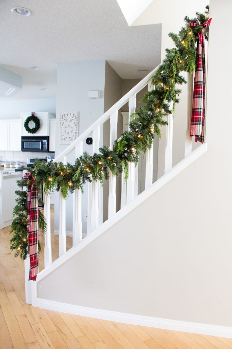 Garland with lights on white staircase railing 