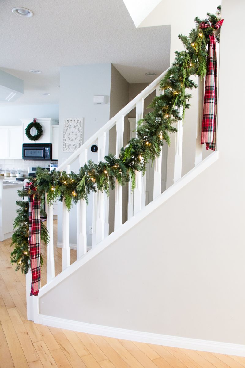 Garland with lights on white staircase railing