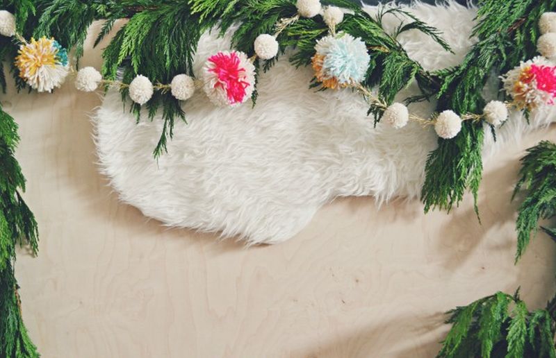 different sizes of pom poms into garland