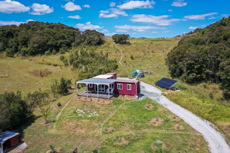 This Off-Grid Shipping Container Tiny Home in New Zealand Charges Electric Car 